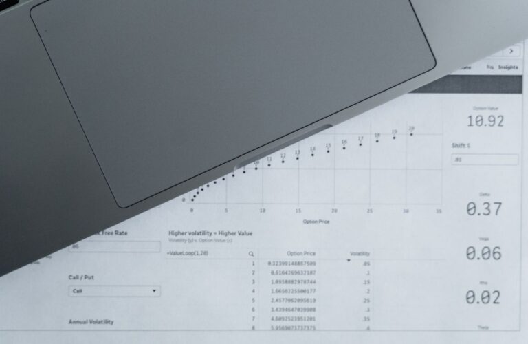 Documentos com dados financeiros ao lado de um notebook