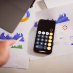 Mesa de trabalho com notebook, gráficos financeiros e calculadora, representando BPO Financeiro e inteligência artificial